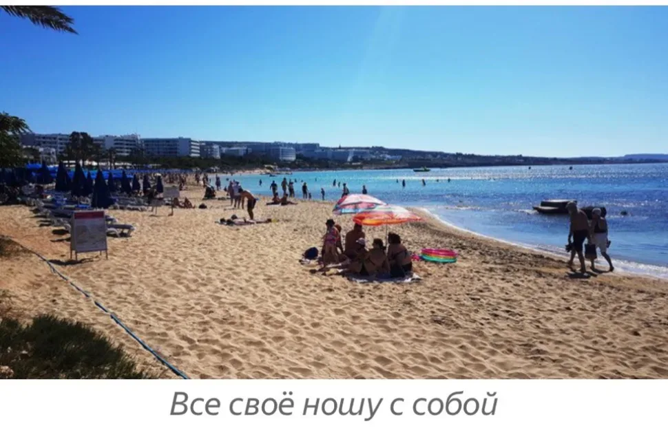 Семьи и туристы с полотенцами и надувными кругами на пляже