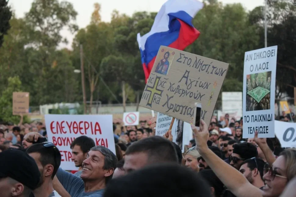 Толпа протестующих с множеством самодельных плакатов и лозунгами на английском