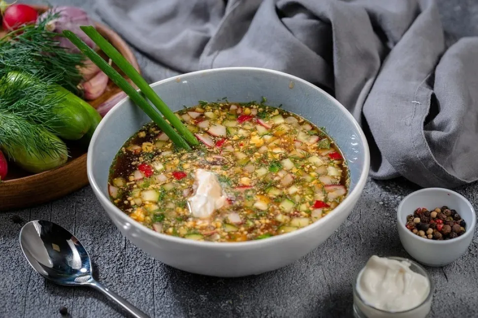 Стакан кваса с кусочками ржаного хлеба и изюмом на тарелке