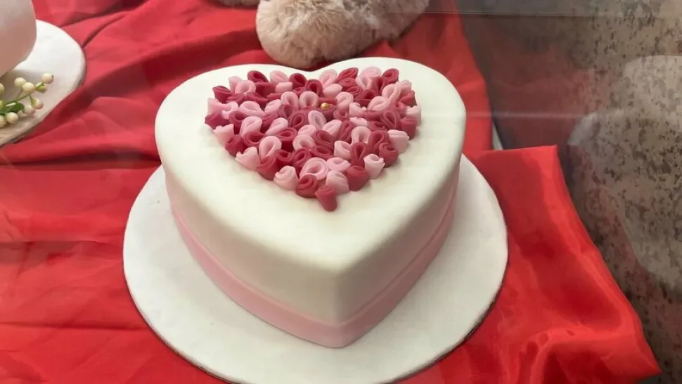 Сердцевидный торт в витрине кондитерской Sweet Nest в романическом оформлении