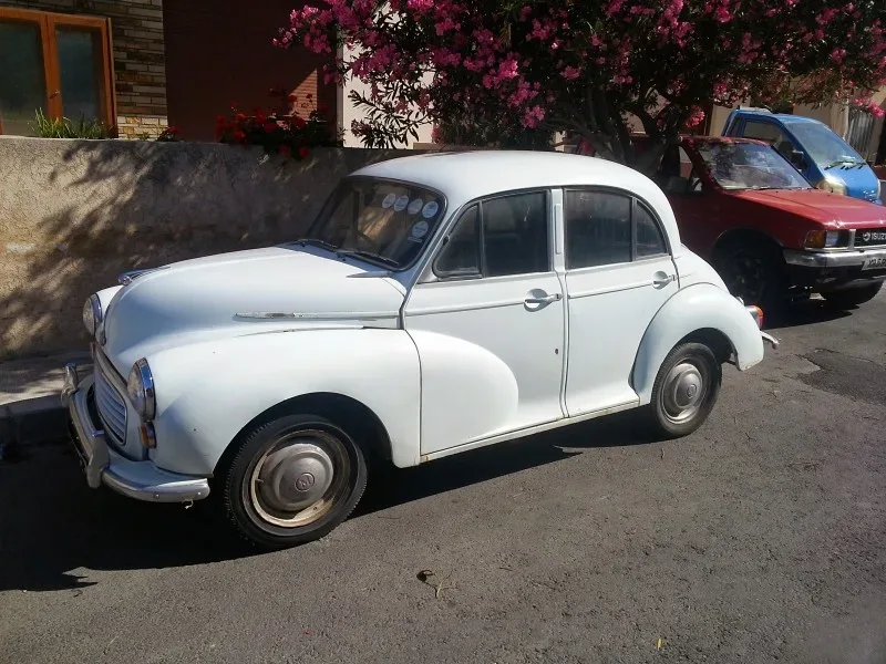 Белый компактный ретро‑автомобиль Morris или похожая классика на улице