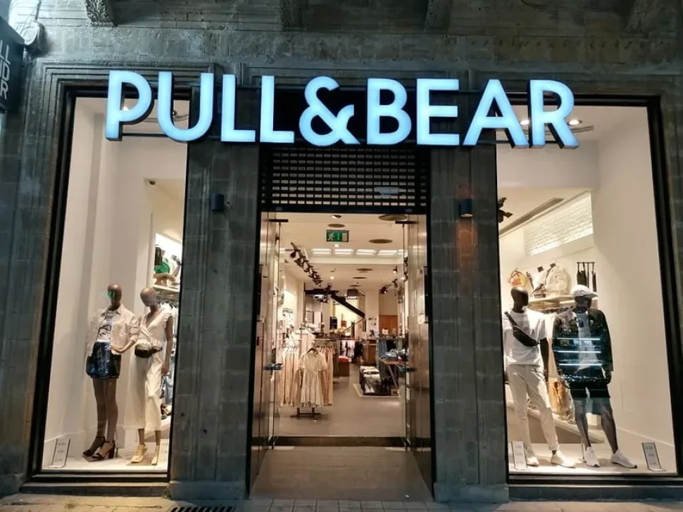 Витрина магазина Bershka с освещённым входом и манекенами
