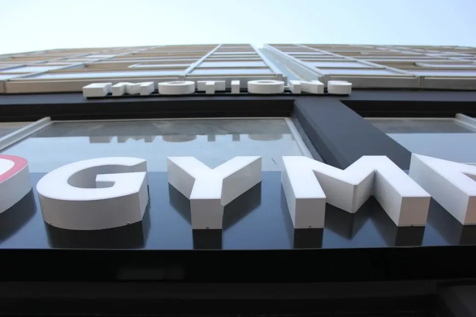 Крупный план объемной световой вывески GYMNAsIUM на фасаде Крупный план объемной световой вывески GYMNAsIUM на фасаде