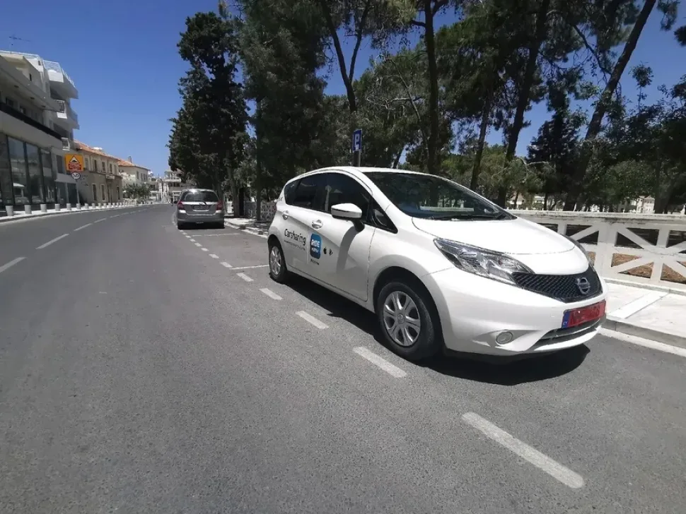 Белый автомобиль каршеринга RideNow припаркован на городской улице Белый автомобиль каршеринга RideNow припаркован на городской улице