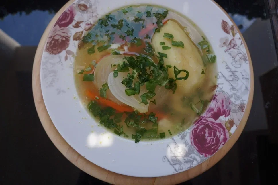 Пасхальный кипрский суп магирица в тарелке с укропом и зелёным луком