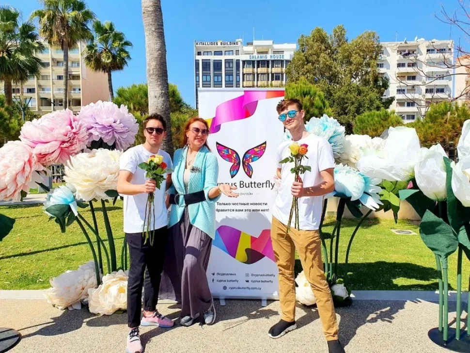 Сотрудники Cyprus Butterfly с розами у официального баннера акции