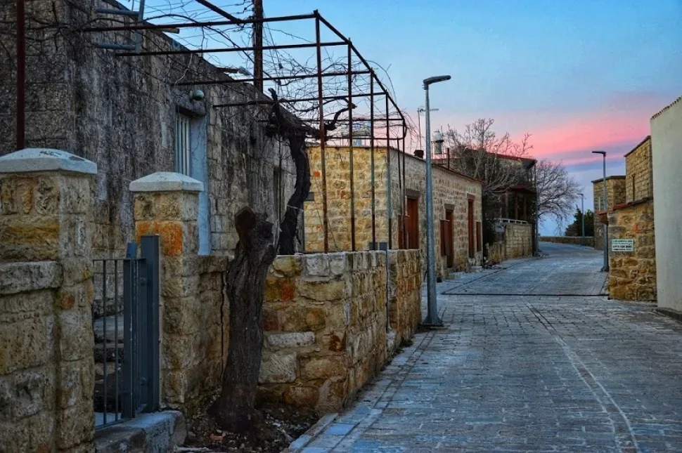 Покосившиеся каменные ограждения и мощёная улица в винной деревне
