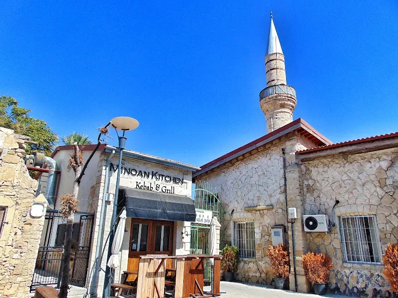 Минарет мечети рядом с кафетерием Minoan Kitchen и вывеской Kebab & Grill