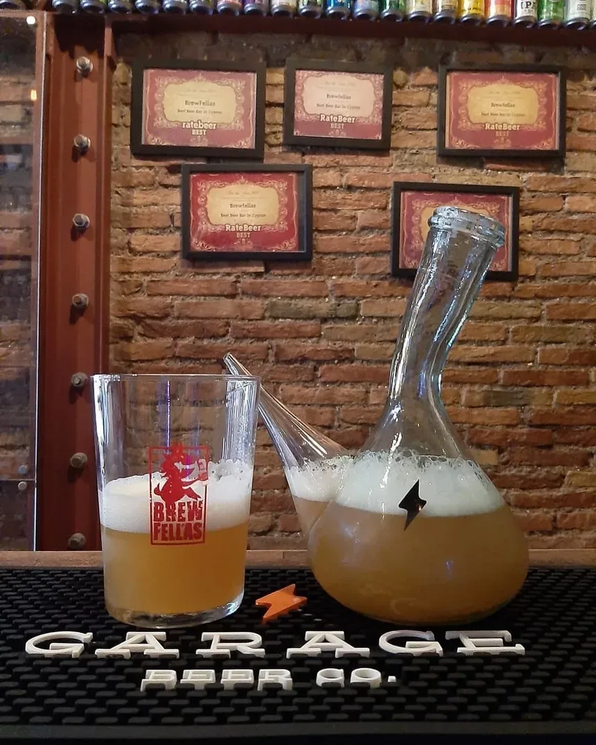 Кувшин и стакан с пивом в пабе Brewfellas на фоне дипломов