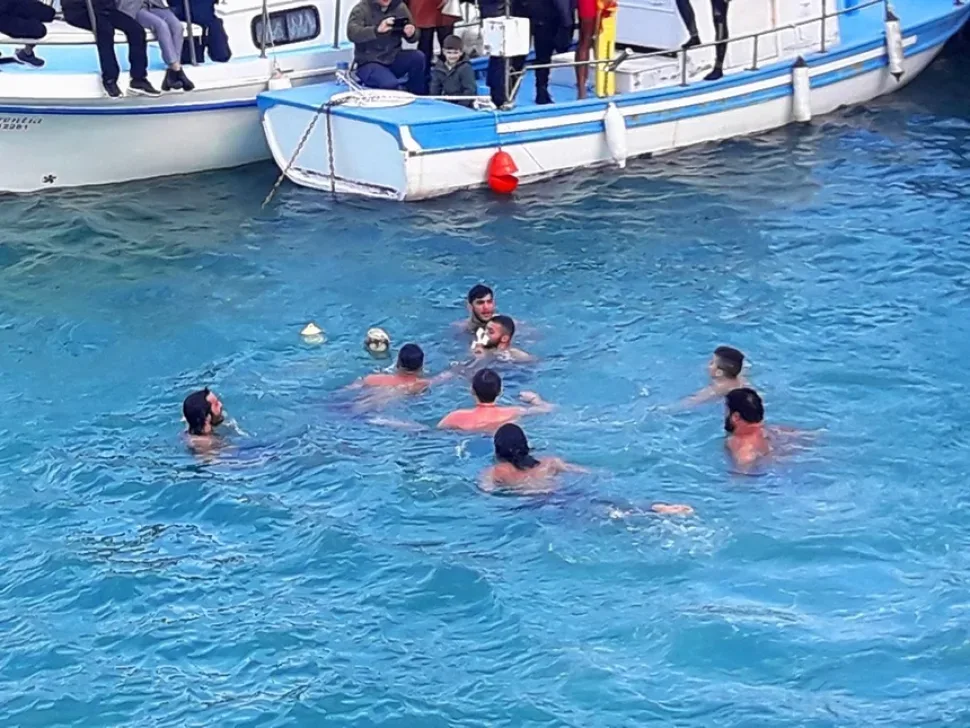 Ныряльщики в воде проходят обмен найденным распятием