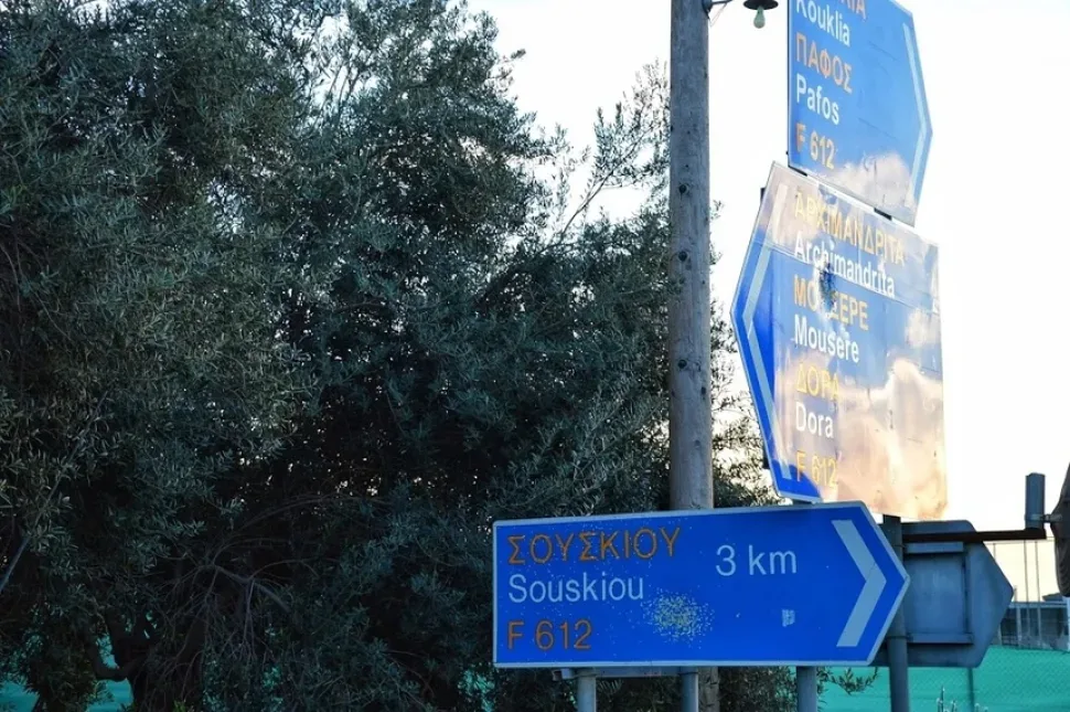 Дорожный указатель с надписью Souskiou у дороги к деревне