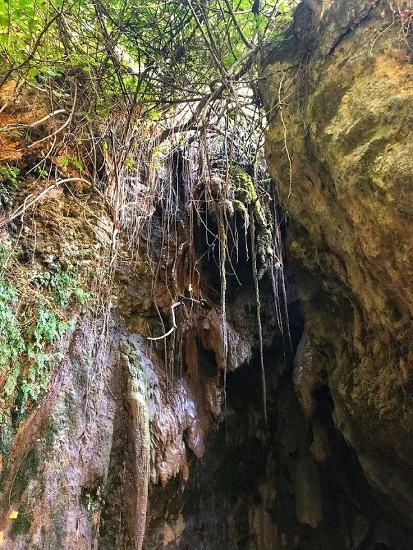 Двухкадровая панорама узкого пещерного прохода и скалистой тропы к водопаду