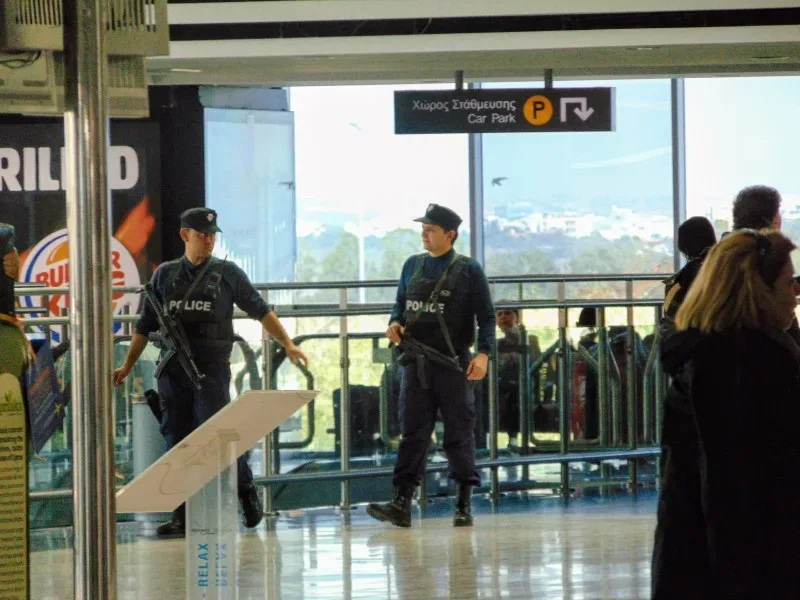 Полицейские с автоматами в терминале аэропорта Ларнаки на посту патруля