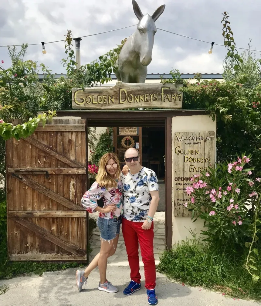 Вход на ферму с табличкой Golden Donkeys Farm и гостями у ворот