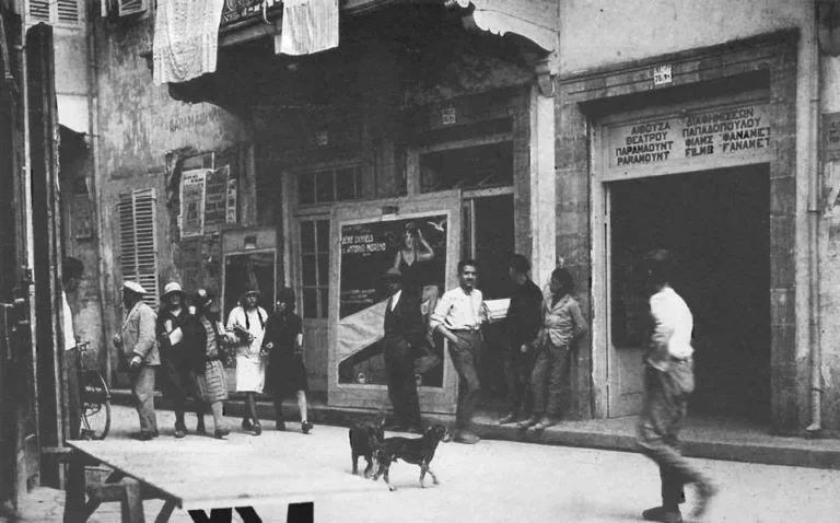 Улица Лидра в Никосии 1928 года с прохожими и кинотеатром Пападопулоса Улица Лидра в Никосии 1928 года с прохожими и кинотеатром Пападопулоса
