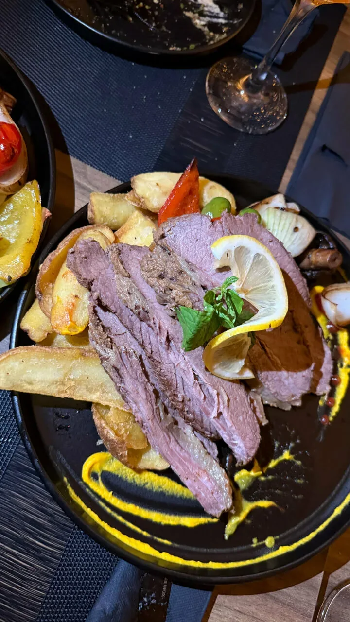 Нарезанная копчёная говядина с картофелем и долькой лимона