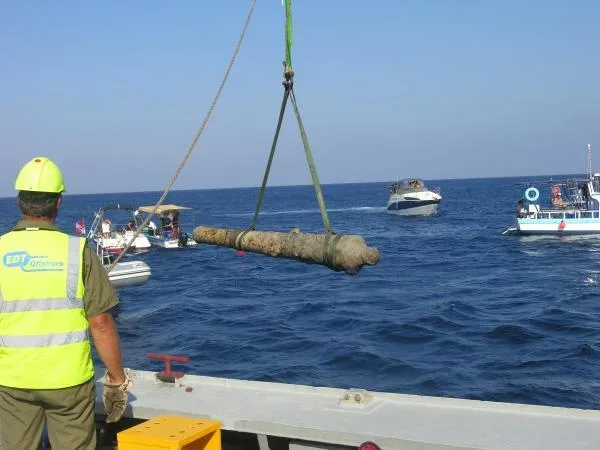 Аквалангист наблюдает за подъемом морского артефакта на поверхность Аквалангист наблюдает за подъемом морского артефакта на поверхность