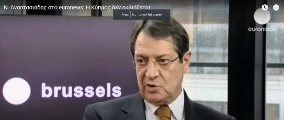 Кадр из интервью: мужчина в студии с логотипом brussels в кадре Кадр из интервью: мужчина в студии с логотипом brussels в кадре