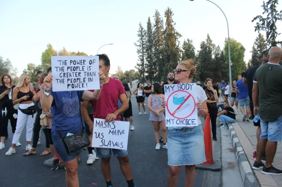 Толпа протестующих с английскими плакатами о правах и свободе перед воротами