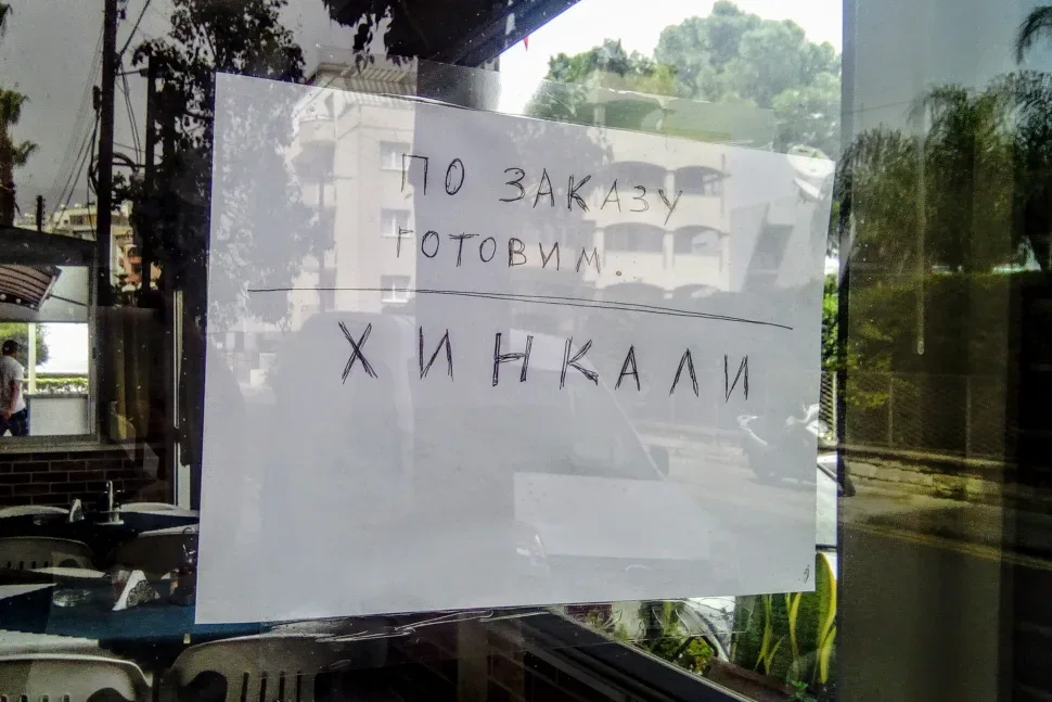 Ручная вывеска на витрине с надписью по заказу готовим хинкали