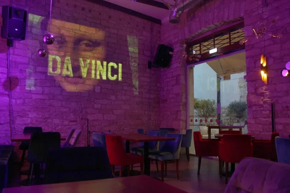 Интерьер рестобара Da Vinci с проекцией названия на каменной стене Интерьер рестобара Da Vinci с проекцией названия на каменной стене