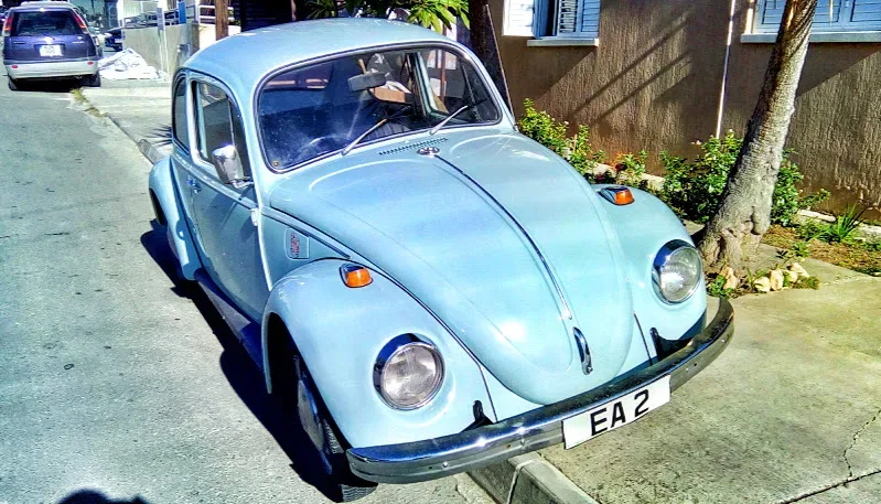 Голубой Volkswagen Beetle классической модели припаркованный в районе Меса Гитонья Голубой Volkswagen Beetle классической модели припаркованный в районе Меса Гитонья