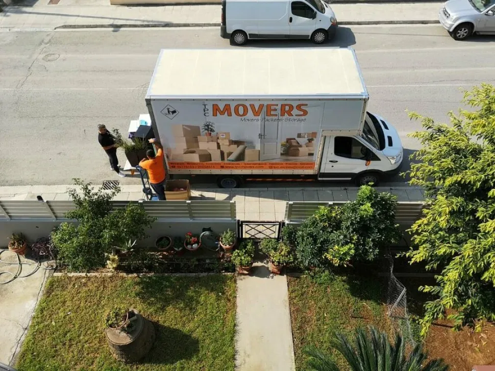 Переезд: грузовик TPC MOVERS у частного дома и погрузка вещей