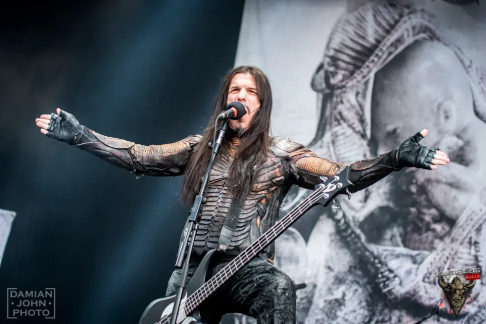 Вокалист Septicflesh на сцене с распростертыми руками, афиша концерта 16 июня