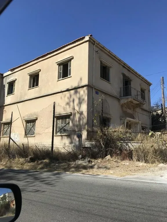 Угловой фасад дома с табличкой названия улицы на стене