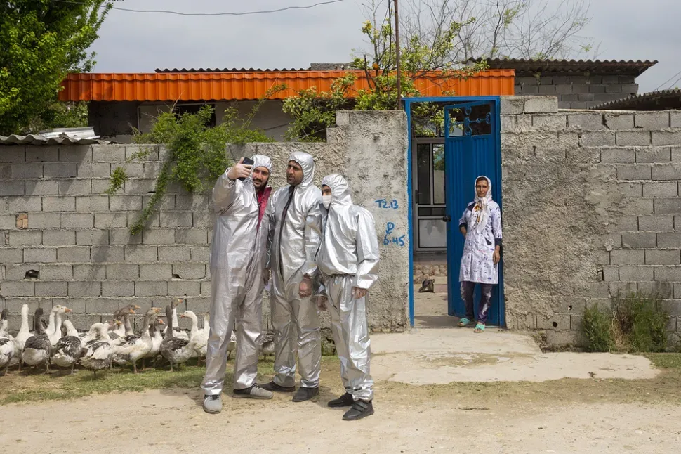 Добровольцы иранского Красного Полумесяца в защитных костюмах делают селфи во время дезинфекции Добровольцы иранского Красного Полумесяца в защитных костюмах делают селфи во время дезинфекции