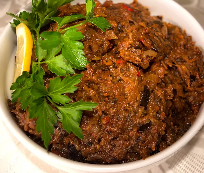 Кусок хлеба, намазанный баклажанной икрой, украшенный петрушкой