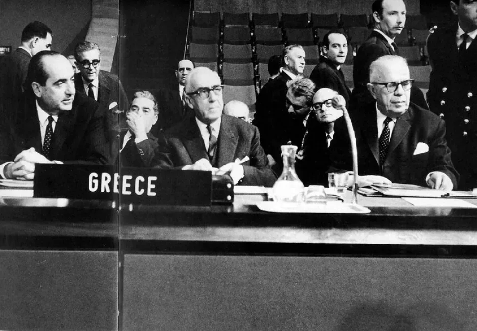Делегация Греции на международной конференции у таблички GREECE