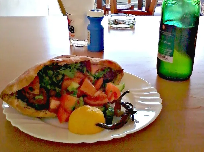 Пита с мясом и свежим салатом, долька лимона и бутылка напитка