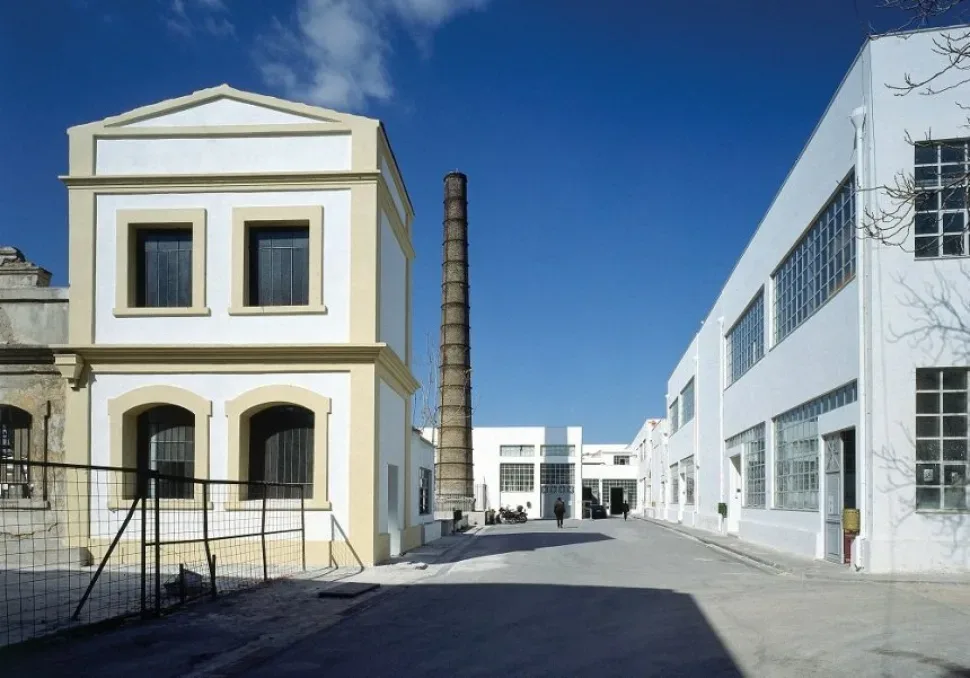 Бывший промышленный корпус и высокая кирпичная труба кампуса Athens School of Fine Arts