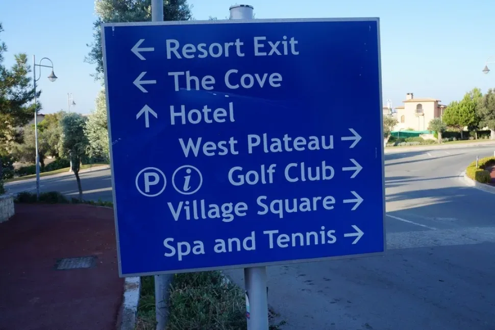 Дорожный указатель с направлениями на гольф‑курорт и Village Square