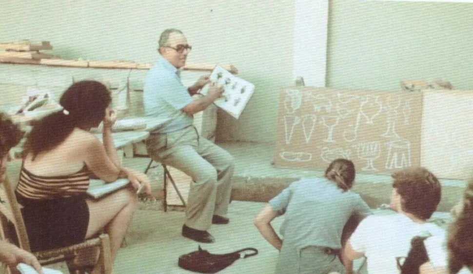 Васос Карагиоргис читает лекцию студентам с рисунками археологических находок