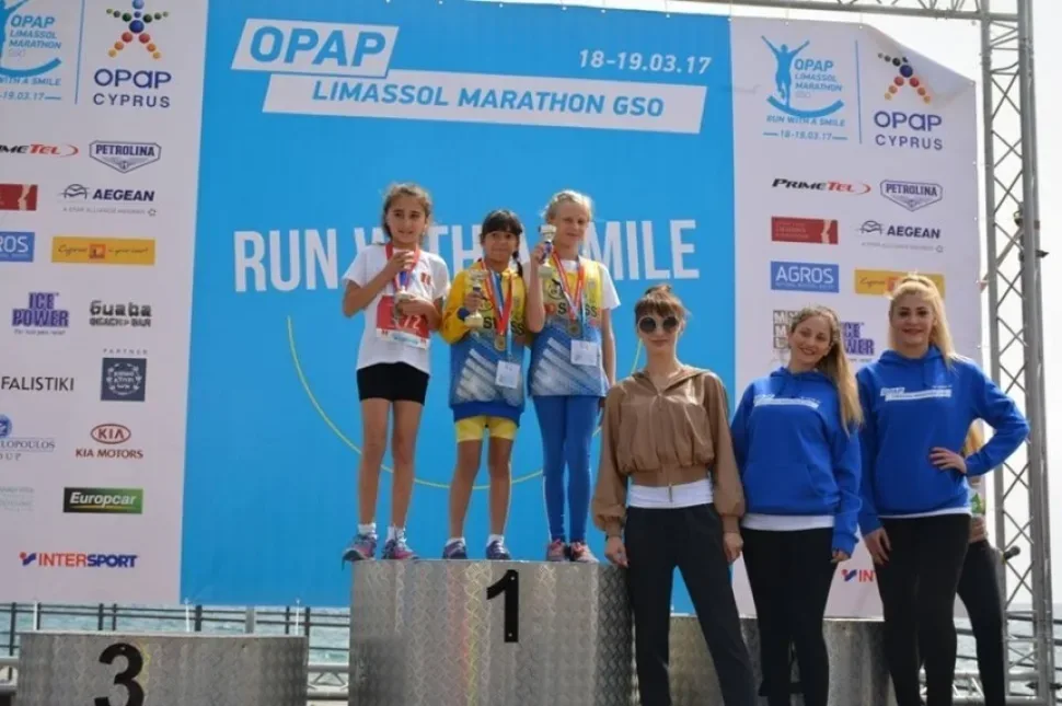 Дети на пьедестале победителей OPAP Limassol Marathon с медалями