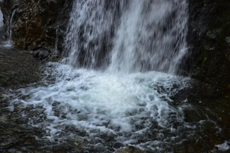 Вертикальный вид падающей воды водопада Хантара с камнями