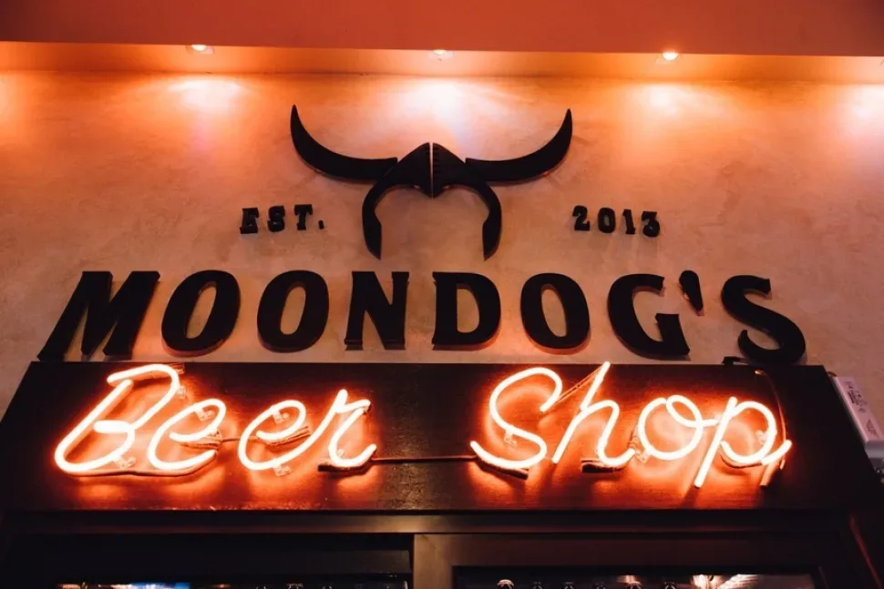 Неоновая вывеска Moondog's Beer Shop над барной стойкой