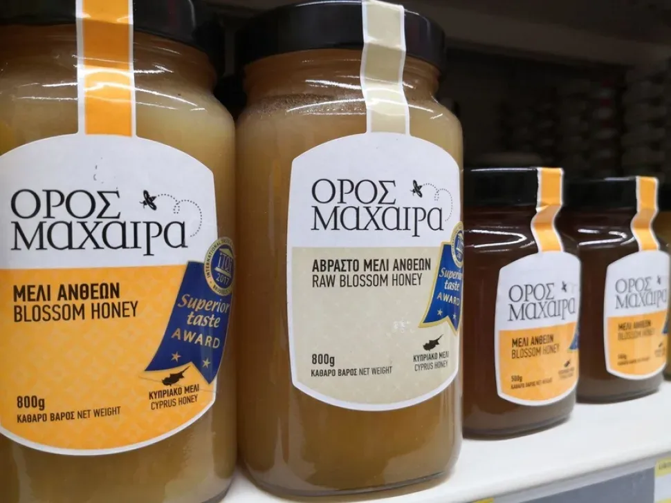 Пчёлы входят в щель белого улья на пасеке