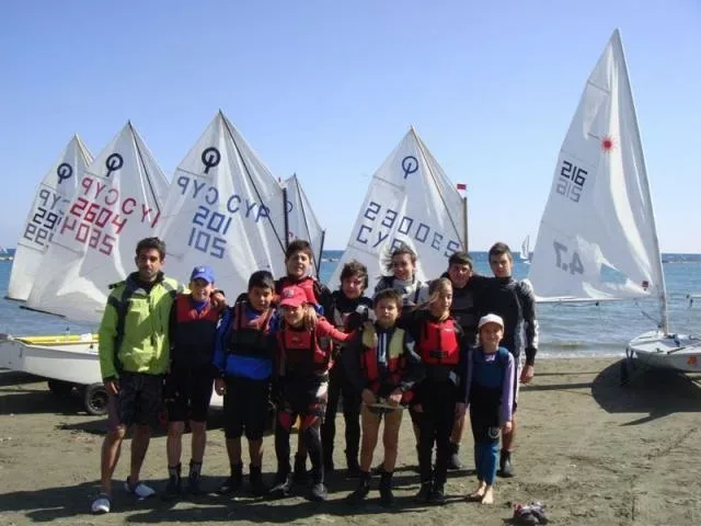 Дети в спасжилетах на пляже на фоне парусников для Famagusta Nautical Club