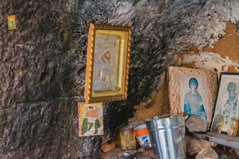 Пластиковый пакет с бутылками и подношениями в углу пещеры