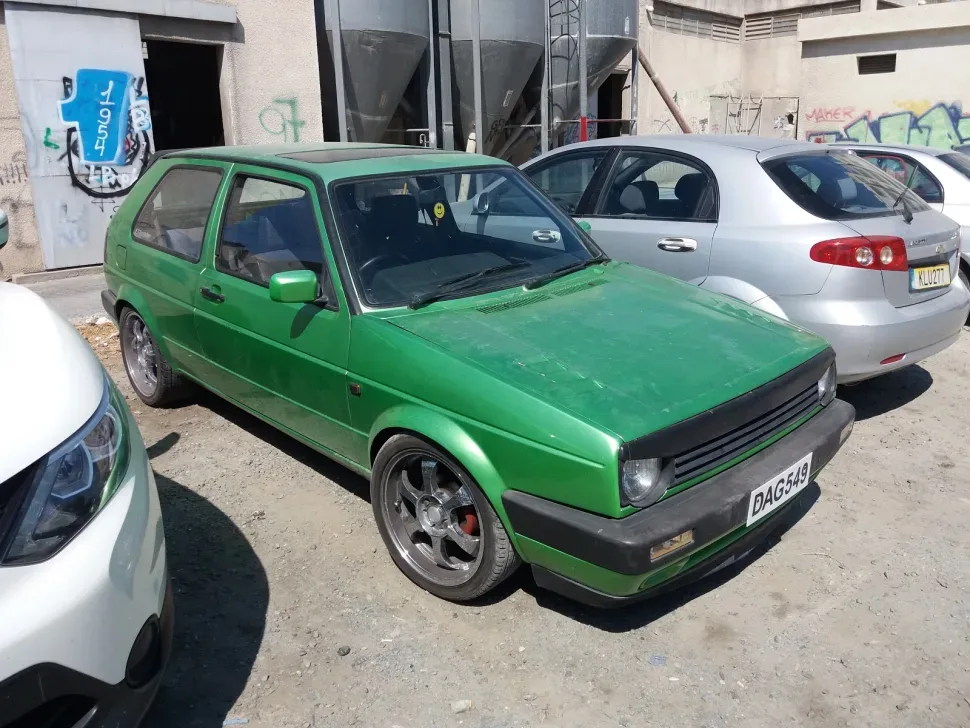 Зелёный подтюнингованный Volkswagen Golf с тёмными дисками