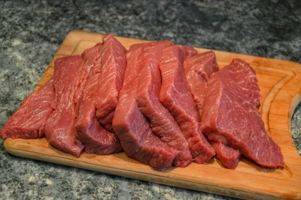 Обжаривающийся лук на сковороде с деревянной лопаткой