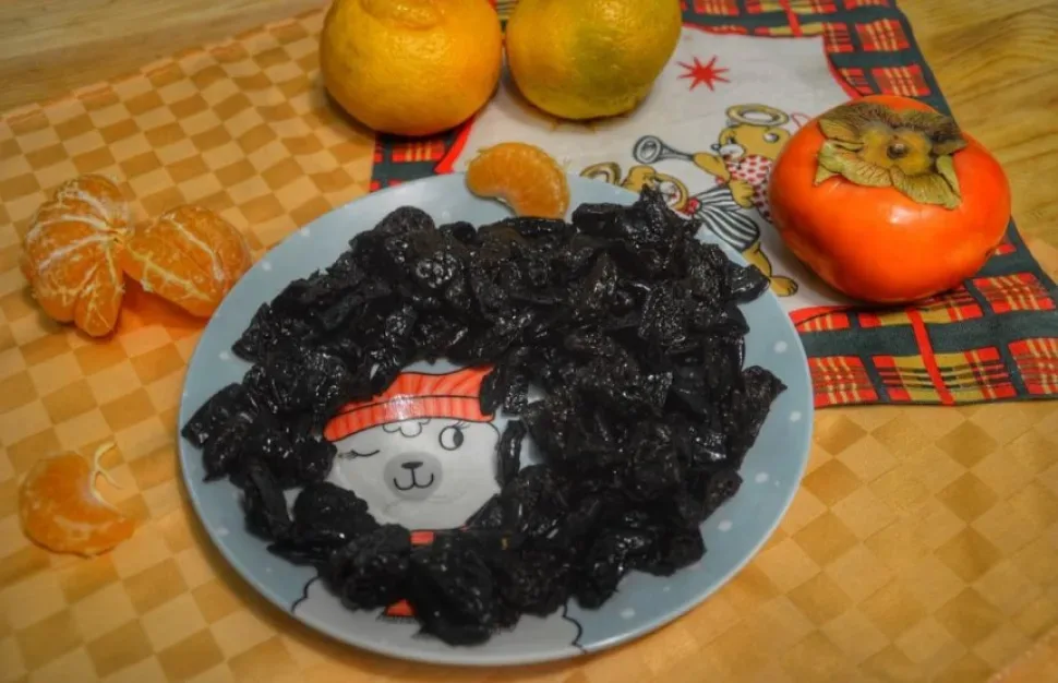 Боковой вид салата с видимыми слоями курицы, чернослива и сыра