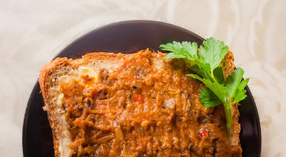 Миска баклажанной икры с лимоном и зеленью, готовая к подаче