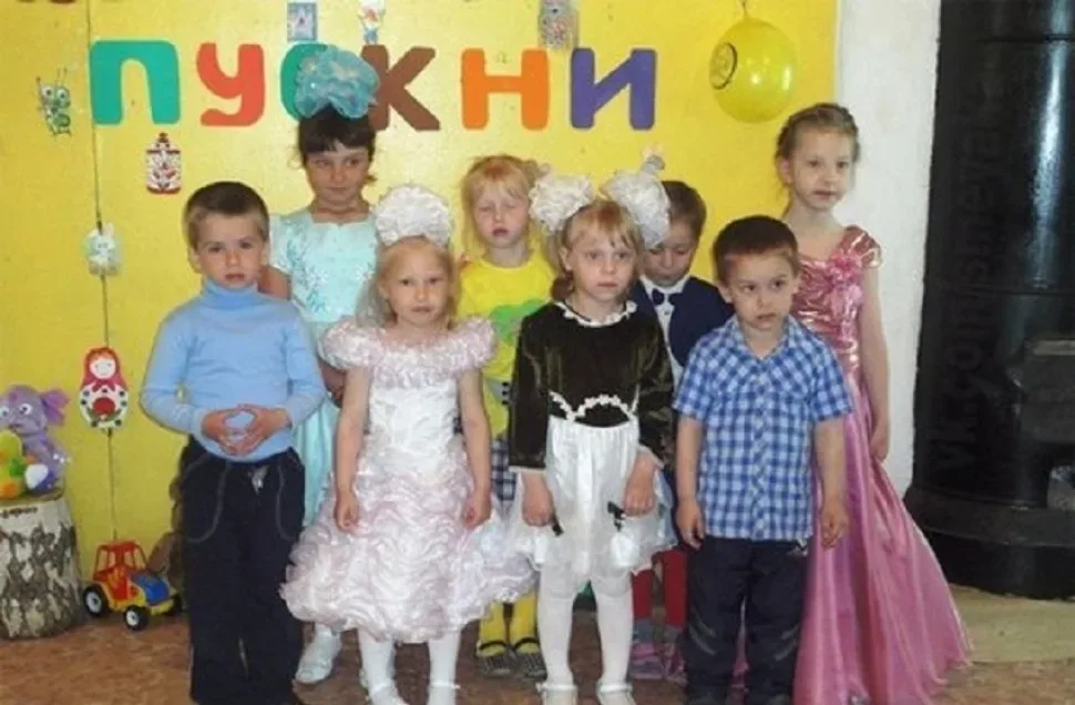 Три ребёнка на коленях у Деда Мороза с разными эмоциями