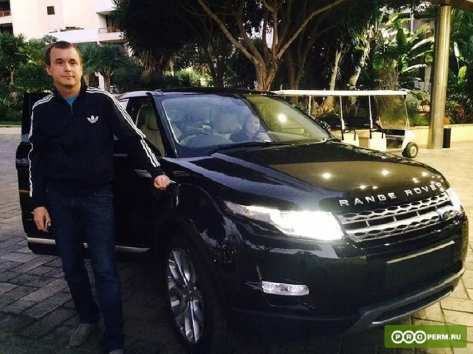 Мужчина в спортивной куртке стоит рядом с чёрным Range Rover
