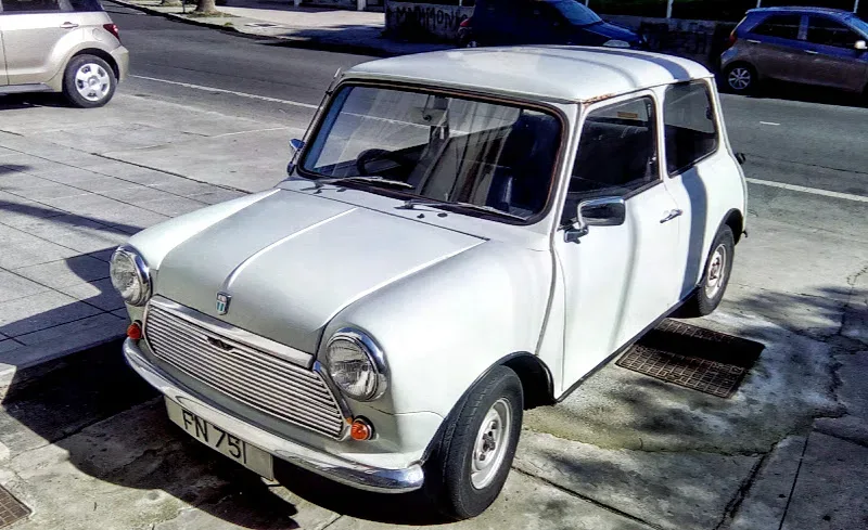 Белый классический Mini припаркованный у тротуара в районе Меса Гитонья Белый классический Mini припаркованный у тротуара в районе Меса Гитонья