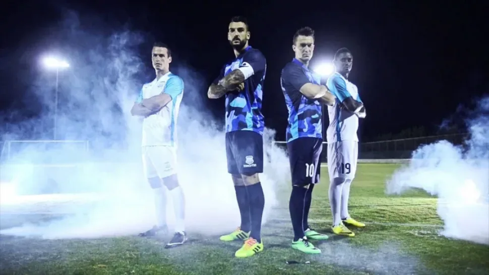 Игроки в бело‑синей форме APOLLON обнимаются в радостном порыве